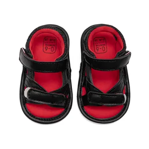 Detail of baby camouflage sandals with red and black straps and Velcro closure