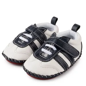 Détail de chaussures bébé avec empiècements bleu marine et semelles souples rouges