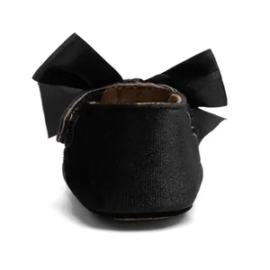 Close-up of black velvet baby princess shoes with a large decorative bow on the heel