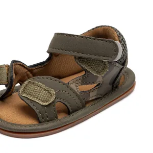 Close-up of camouflage baby sandals with olive green straps and dual velcro fasteners