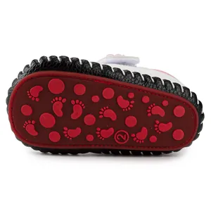Detailed view of the dark red anti-slip rubber sole with cute footprint patterns for baby shoes