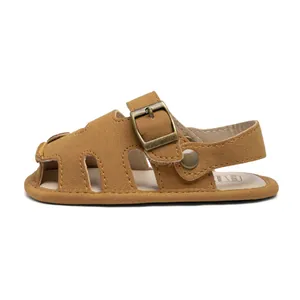 Detail view of brown PU leather baby sandals with bronze buckle and closed-toe design