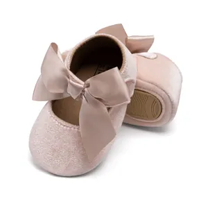 Detail view of pink velvet baby princess shoes with satin bow and non-slip rubber sole