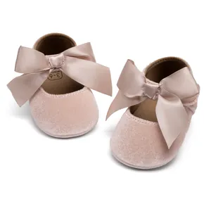 Detailed close-up of pink velvet baby shoes with large satin bows and size 3-6 months
