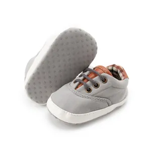 Detail of baby canvas shoes showing soft anti-slip soles and classic plaid lining
