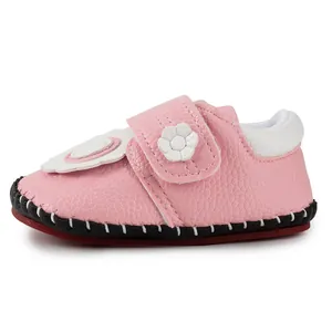 Close-up of pink baby walker shoes with lychee texture leather and floral velcro strap