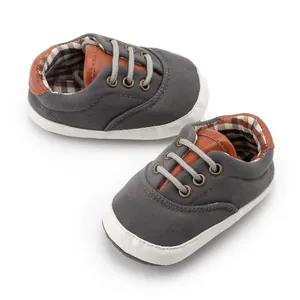 Detailed close-up of baby canvas walking shoes with soft soles and brown leather trim