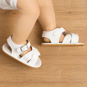 White baby sandals with breathable soft soles and cross-strap metal buckles for infants