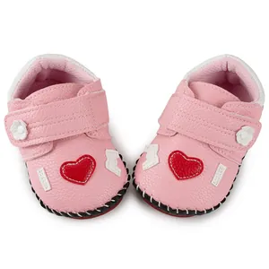 Detailed top view of pink baby walker shoes with heart patches and velcro straps
