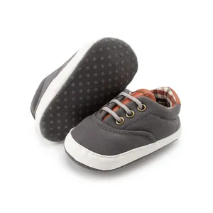Detail view of baby canvas shoes showing non-slip soft sole and classic plaid lining