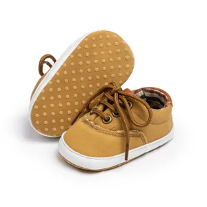 Detail of infant canvas shoes with slip-resistant dotted soles and classic plaid lining