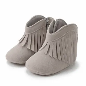 Detail view of grey fringe baby boots featuring soft suede texture and side zipper