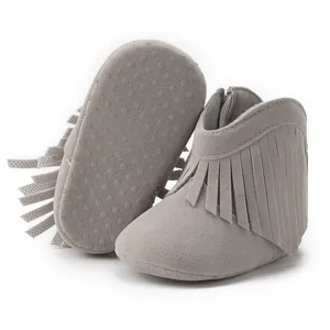 Detail of light grey baby tassel boots showing non-slip sole and soft suede texture