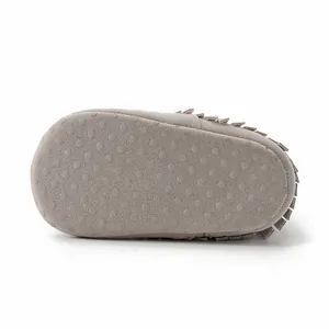 Detail of grey baby fringe boots showing anti-slip dot soles and suede texture