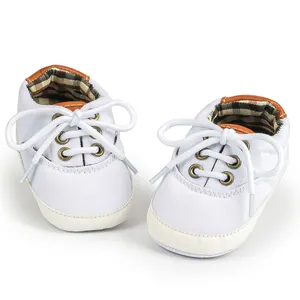 White canvas baby shoes with brown leather heel and soft flexible sole for toddlers