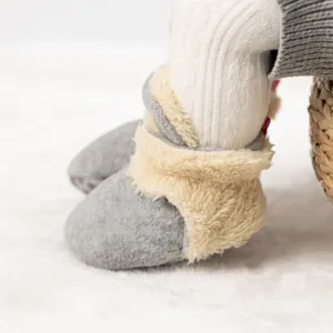 Detail von warmen grauen Babyschuhen mit weichem cremefarbenem Lammfellimitat-Futter