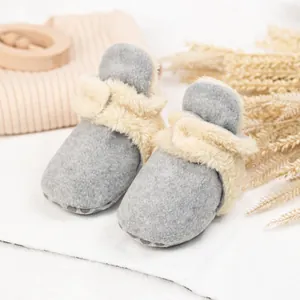 Makro-Detail von grauen Fleece-Babyschuhen mit Plüschfutter und rutschfester Sohle