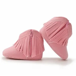 Detail view of pink suede baby tassel boots with side zipper and soft fringe