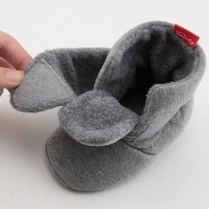 Macro shot showing plush fleece lining and adjustable side closure of baby winter shoes