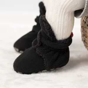 Nahaufnahme der schwarzen Baby-Fleece-Schuhe mit rutschfester Sohle und Warmfutter