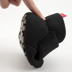 Close-up showing the extreme flexibility and soft non-slip sole of the black baby shoes