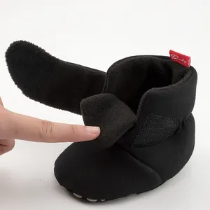 Detail of warm black baby shoes featuring soft fleece lining and secure velcro strap