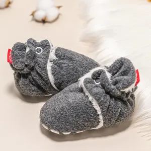 Detailansicht grauer Baby-Fleeceschuhe mit weißem Plüschfutter und rotem Fersen-Akzent