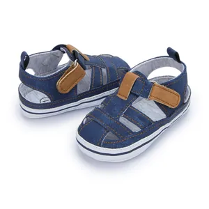 Detailansicht der Babysandalen mit blauem Denim-Stoff, braunen Riemen und rutschfesten Sohlen