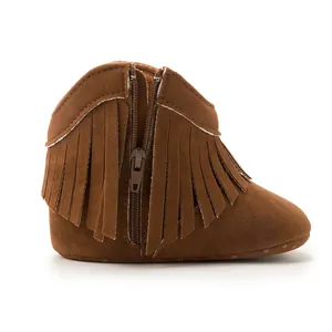 Macro detail of baby fringe boots showing brown faux suede texture and side zipper