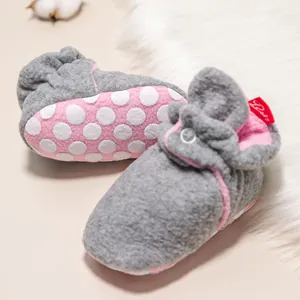 Detail von warmen Baby-Winterschuhen aus grauem Fleece mit rutschfester Noppensohle