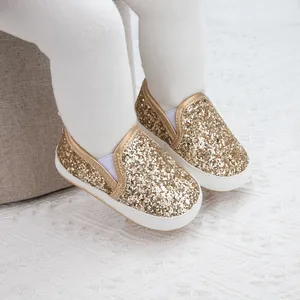 Detailed close-up of golden sequin baby walker shoes with soft white non-slip soles