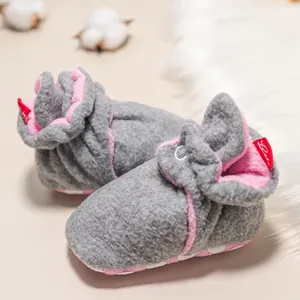 Nahaufnahme warmer grauer Baby-Stiefel mit rosa Futter und rutschfesten Noppensohlen