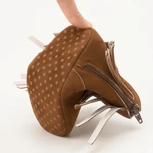 Close-up of flexible soft sole baby bootie with non-slip dots and YKK zipper detail