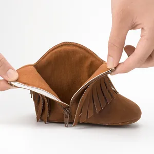 Detail showing side zipper closure and soft lining of brown infant fringe boots