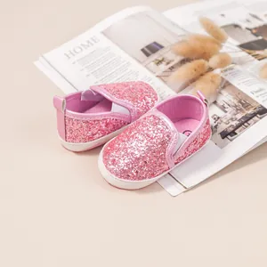 Macro detail of sparkly pink sequin baby loafers with soft non-slip white soles