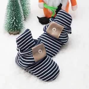 Close-up of blue striped baby knit boots with warm fleece lining and leather accents