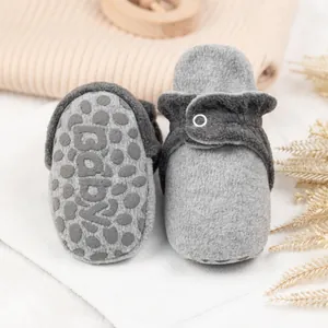 Detail von weichen Baby-Fleece-Schuhen mit rutschfester Sohle und Baby-Aufdruck
