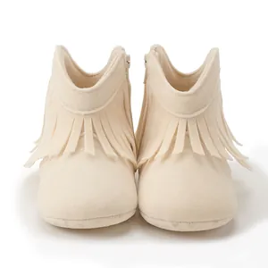 Detail of baby tassel boots in cream faux suede with side zipper and soft soles