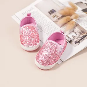 Detail view of pink glitter baby walking shoes with slip-on soft soles for infants