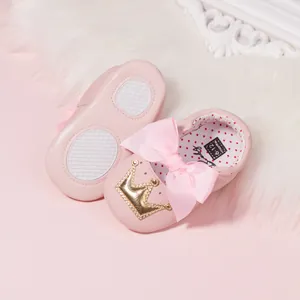 Pink infant walker shoes with soft non-slip soles and large decorative ribbon bows
