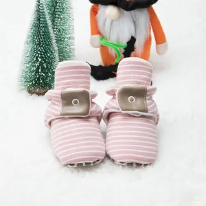 Detail view of pink striped baby walking shoes with anti-slip dotted soft soles