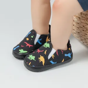 Detailansicht der Baby-Slipper mit bunten Dinosaurier-Mustern und weichem Canvas-Material