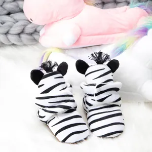 Detailed view of zebra striped baby shoes with soft plush ears and fun black yarn fringe