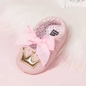 Close-up of pink baby shoes with bow, crown detail and 6-12 months size label