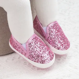 Close-up of pink sequined slip-on baby walking shoes with white elastic side bands