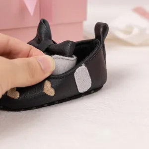 Detail of baby walking shoes with heart embroidery and velcro strap closure