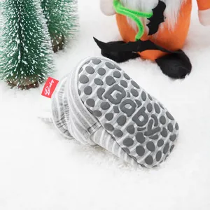Close-up of grey striped baby sock shoe with anti-slip silicone grippers on sole