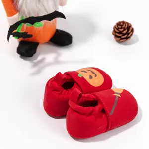 Close-up of red Halloween baby shoes with pumpkin and witch broom designs