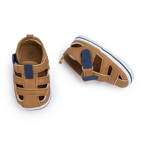 Nahaufnahme von braunen Baby-Sandalen aus Canvas mit atmungsaktiven Ausschnitten und Riemen