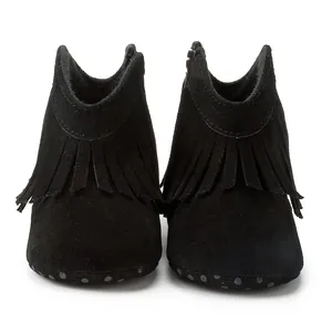Detail of baby fringe boots in black suede with side zipper and anti-slip dotted sole